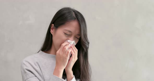 Woman sneezing and feeling sick