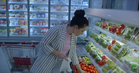 Young Woman in a the Grocery Department of a Supermarket Is Buying Up Food Concept Where People Are