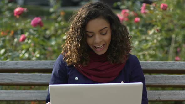 Cheerful Multiracial Girl Making Video Call on Laptop, Talking With Friends