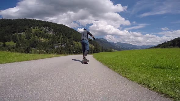 A skateboarder downhill skateboarding racing on a mountain road.
