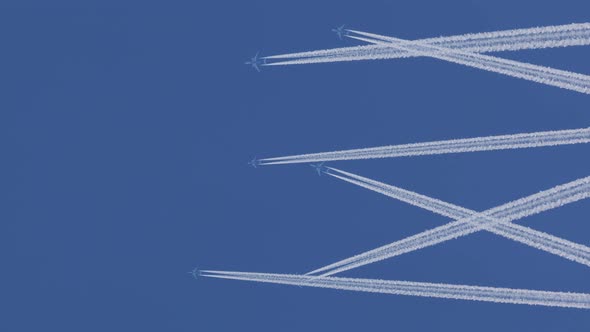 Multiple Aircraft Against Clear Blue Sky with Contrails