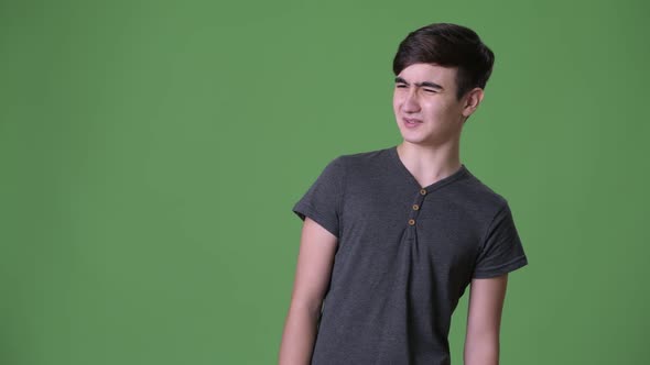 Young Handsome Iranian Teenage Boy Against Green Background