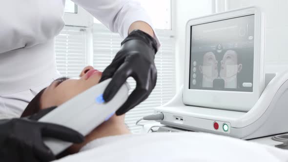 Body Massage Young Woman Having an Electric Massage on Her Face with a Monitor with Visual of Her