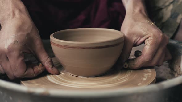 Potter Shapes the Clay Product with Pottery Tools on the Potter's Wheel Top View Toned Cinematic