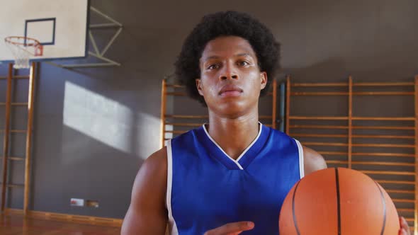 Portrait of african american male basketball player holding ball