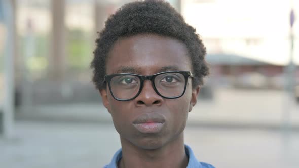 Close Up of Young African Man Looking at the Camera Outdoor