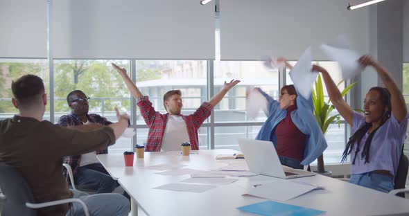 Group of Business People Celebrating By Throwing Business Papers in Air