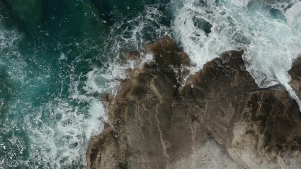 Aerial Overhead Top Down Birds Eye View of Ocean Waves Crashing on Rocks