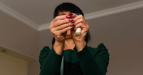 Step by step, woman dressmaker pulling thread into the needle