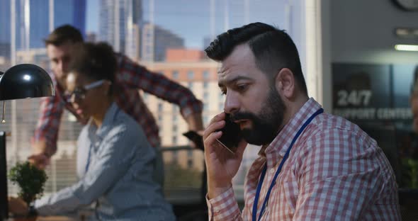 Man Talking To Phone at an Office