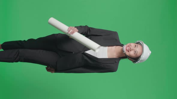 Asian Female Engineer With Blueprint Looking Around While Walking In The Green Screen Studio