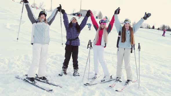 Women Snowboarders and Skiers on Mountain Slope Talking and Relaxing After Slide