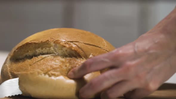 Cutting freshly baked round of white bread