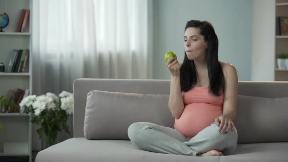 Pregnant Lady Eating Apple, Telling Future Child How Delicious and Useful It Is