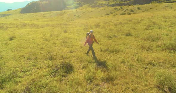 Flight Over Backpack Hiking Tourist Walking Across Green Mountain Field