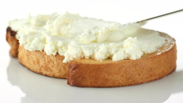 Spreading cream cheese On Bread with knife, close up