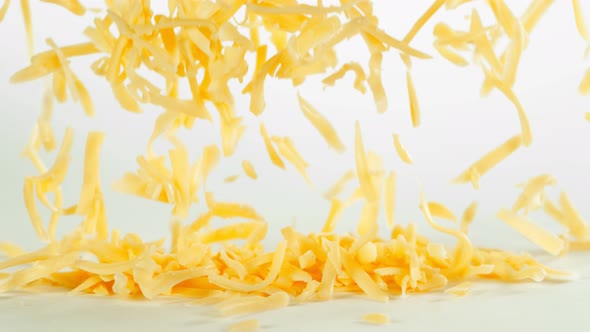 Super Slow Motion Shot of Grated Cheddar Cheese Falling on White Background at 1000 Fps