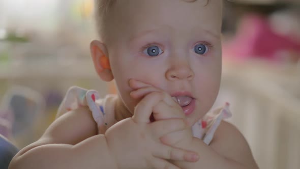 Cute Baby Girl in a Round Crib Staring