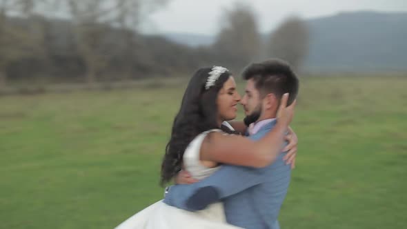 Wedding Couple Running Near Mountain River. Groom and Bride in Love