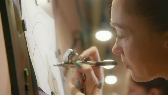 Woman Artist Learns to Paint with Airbrush with Acrylic Dye Paper and Easel