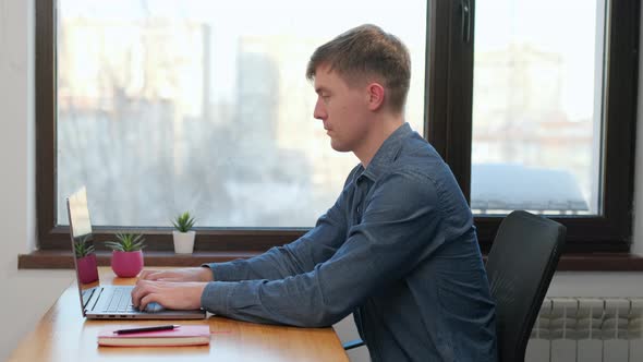 Scrolling, Surfing Web, Looking at the Screen. Professional Creative Millennial Sitting at His Desk 