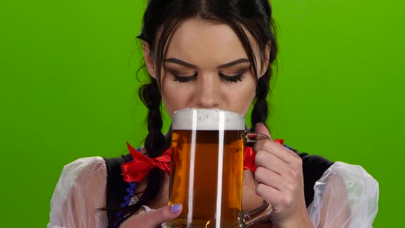 Oktoberfest Girl Flirting and Drinking Beer From a Glass. Green Screen