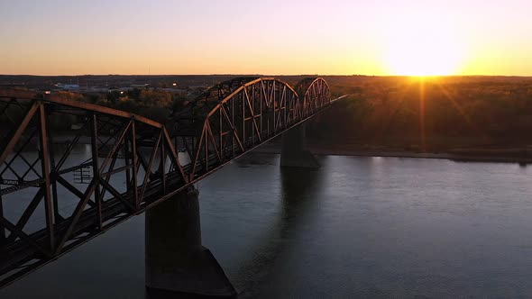 Flying along historic old railroad bridge in North Dakota at sunset