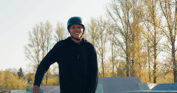 Proud Confident Darkskinned Man Wearing Helmet Walks Through Park Ramps Riding Low Bike Beside Him