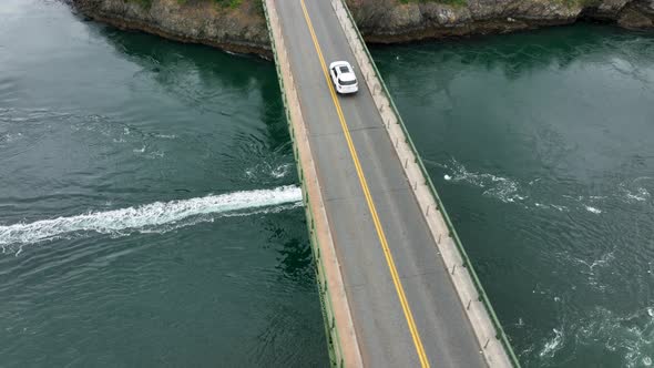 Aerial shot of a boat passing underneath the bridge at Deception Pass.