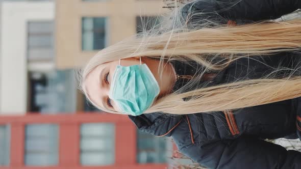 Blonde Girl in a Medical Mask Sitting on the Bench.