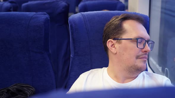 Man in Glasses Enjoy Trip Home While Sitting at Window and Thinking