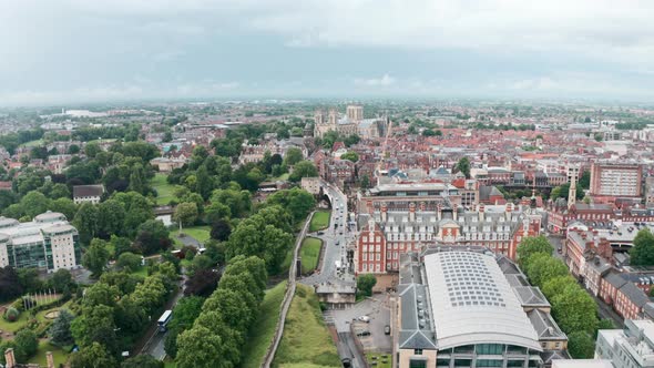 Low establishing drone shot towards York Minster Cathedral over city wall cloudy day