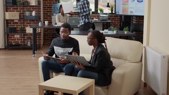 Man Signing Work Documents and Talking to Woman in Office