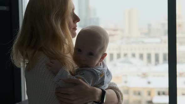 close-up mother and child looking out the window at home