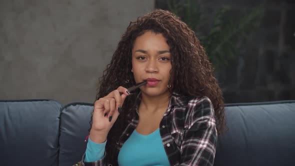 Pretty Black Woman with Pen Thinking Over Something