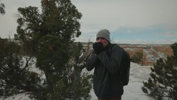 Cold Shivering man trying to stay warm in the woods after snowstorm