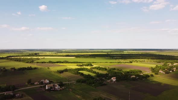 Aerial view of endless lush pastures and farmlands. Beautiful countryside with emerald green fields