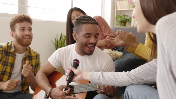 Happy Multiracial Friends Having Fun Singing and Playing the Guitar at Home
