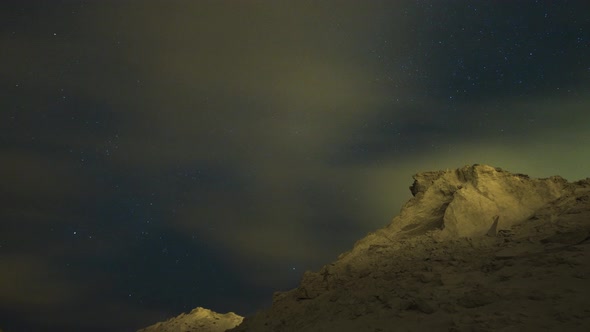 Amazing time-lapse of moving star trail and milky way in blue sky at night in desert with mountain