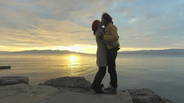 Couple kissing at sunset on at seaside