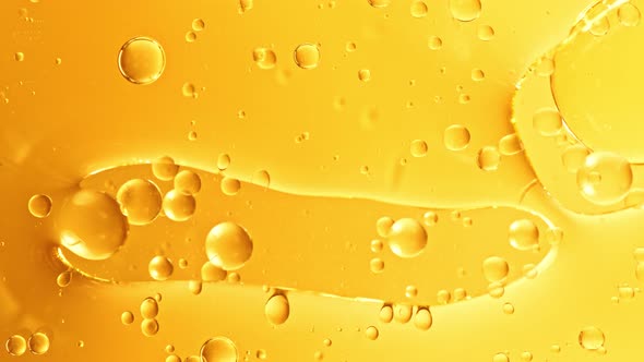 Super Slow Motion Shot of Moving Oil Bubbles on Golden Background at 1000Fps