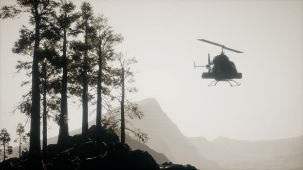 Extreme Slow Motion Flying Helicopter Near Mountain Forest alt
