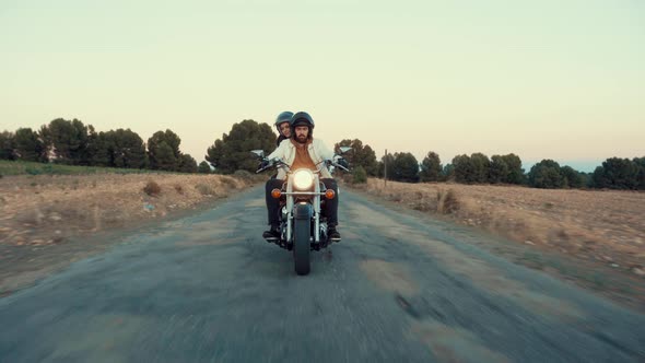 Couple Rider Leisurely Motorcycling In The Road Passing By Countryside Fields. - pullback