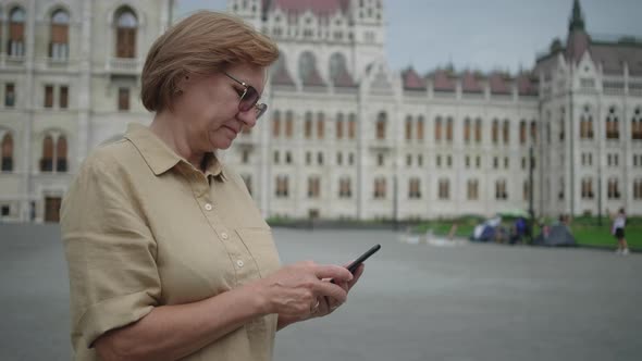 Mature Woman with Cell at Kossuth Square in Budapest Hungary