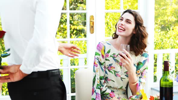 Man offering rose to woman