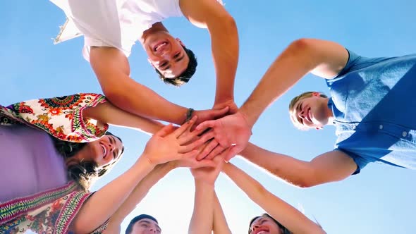 Group of friends forming handstack at beach