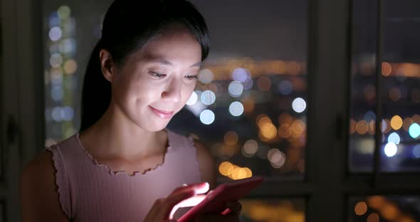 Woman work on mobile phone at home in the evening