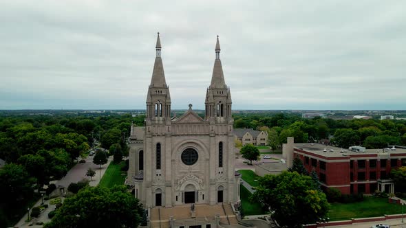 Drone view looking up the cathedral with the Sioux Falls cityscape in the background.