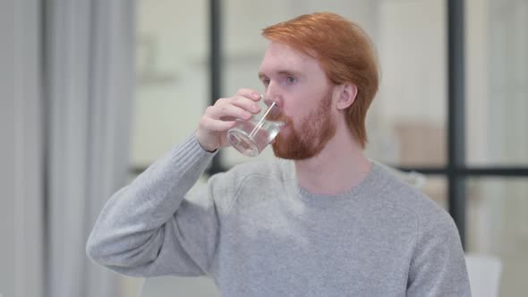 Young Beard Redhead Man Drinking Water