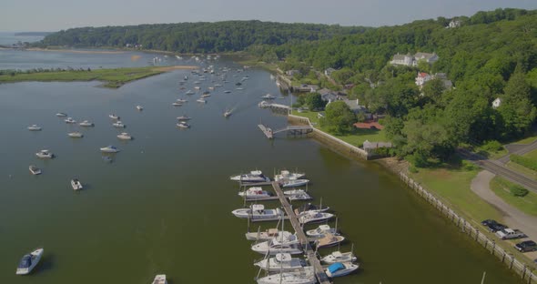 Aerial View of a Small Marina and Boats Anchored on Harbor Near a Small Town